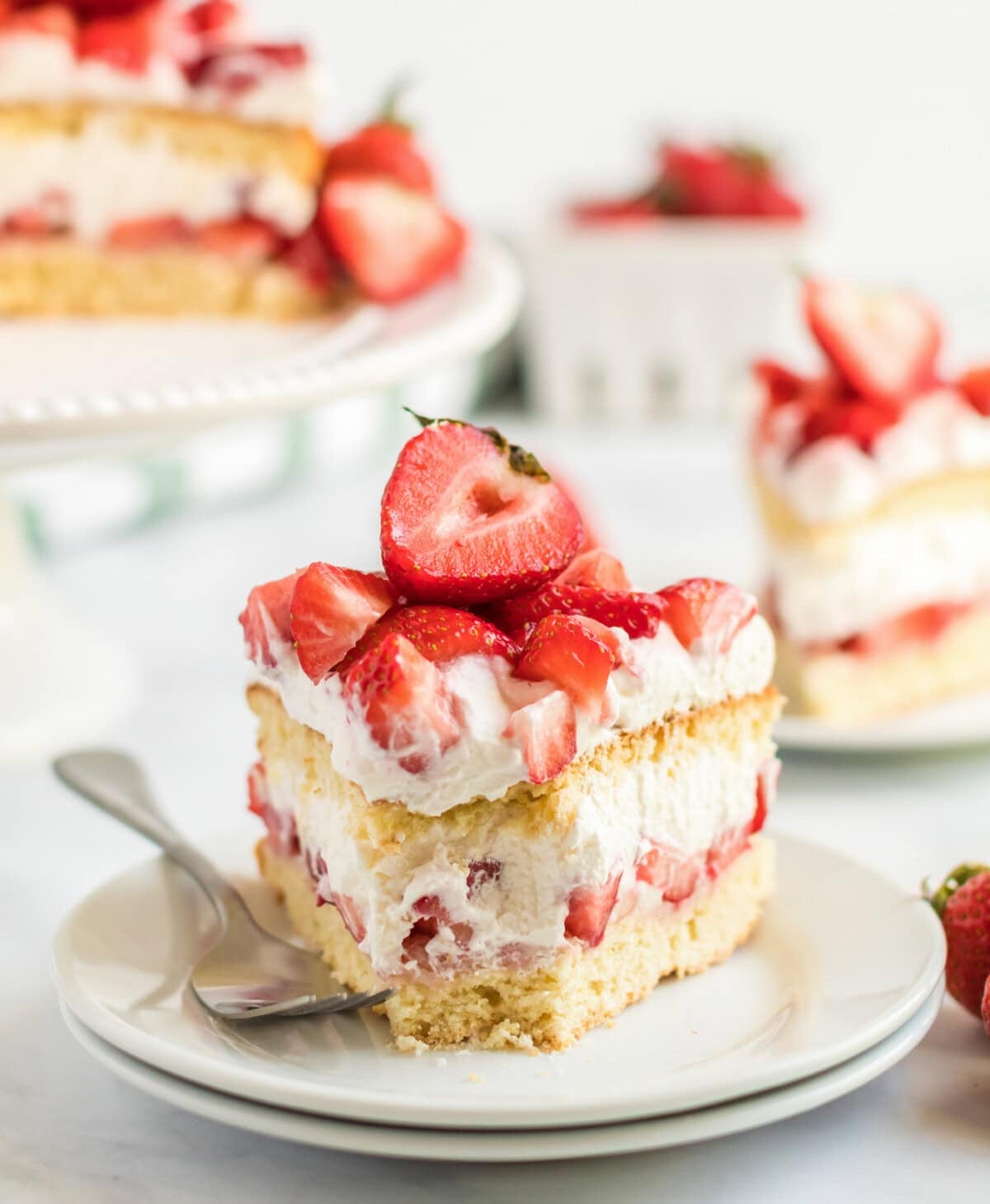 slice of strawberry shortcake cake with a bite out of it