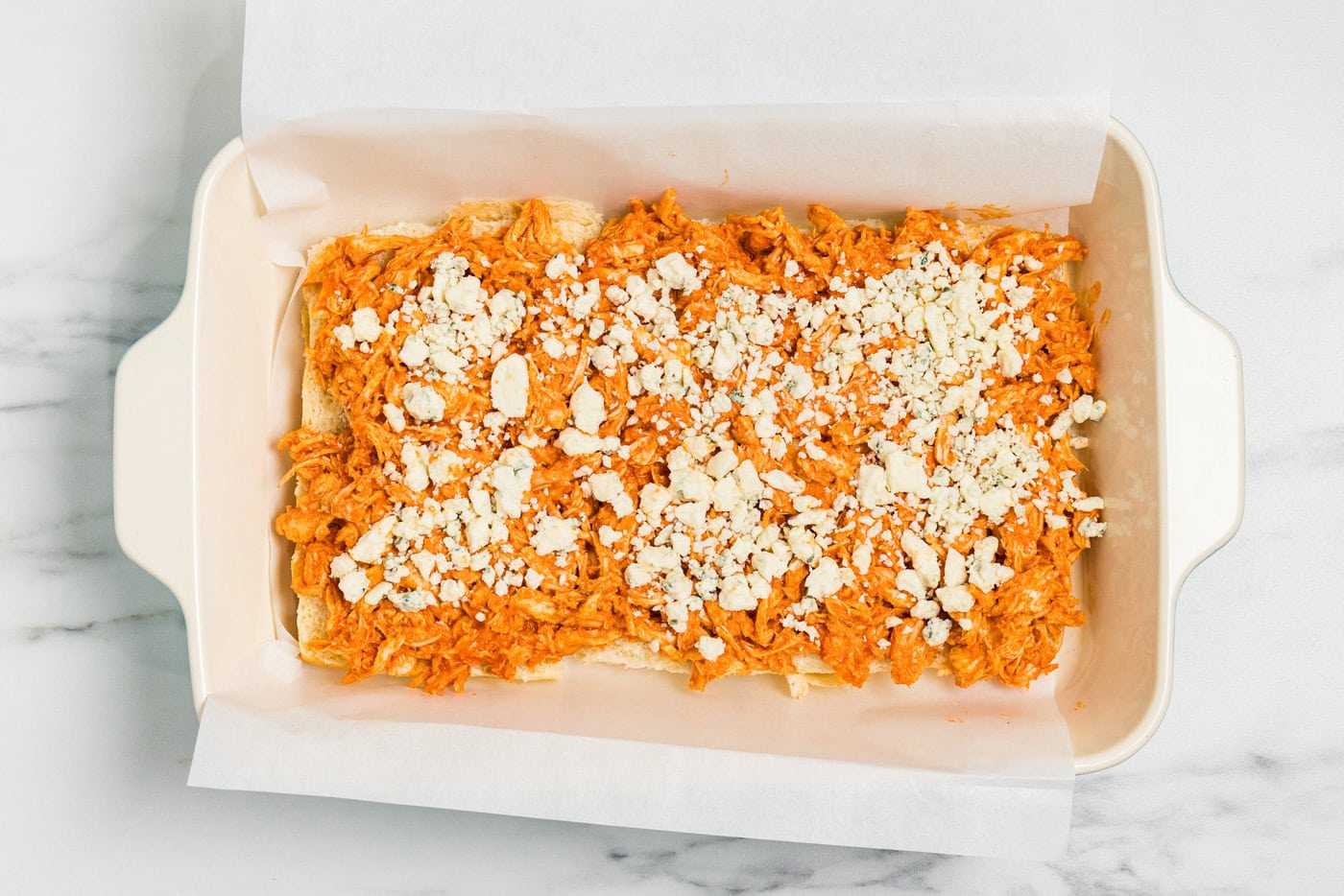 Blue cheese crumbles sprinkled over the buffalo chicken layer