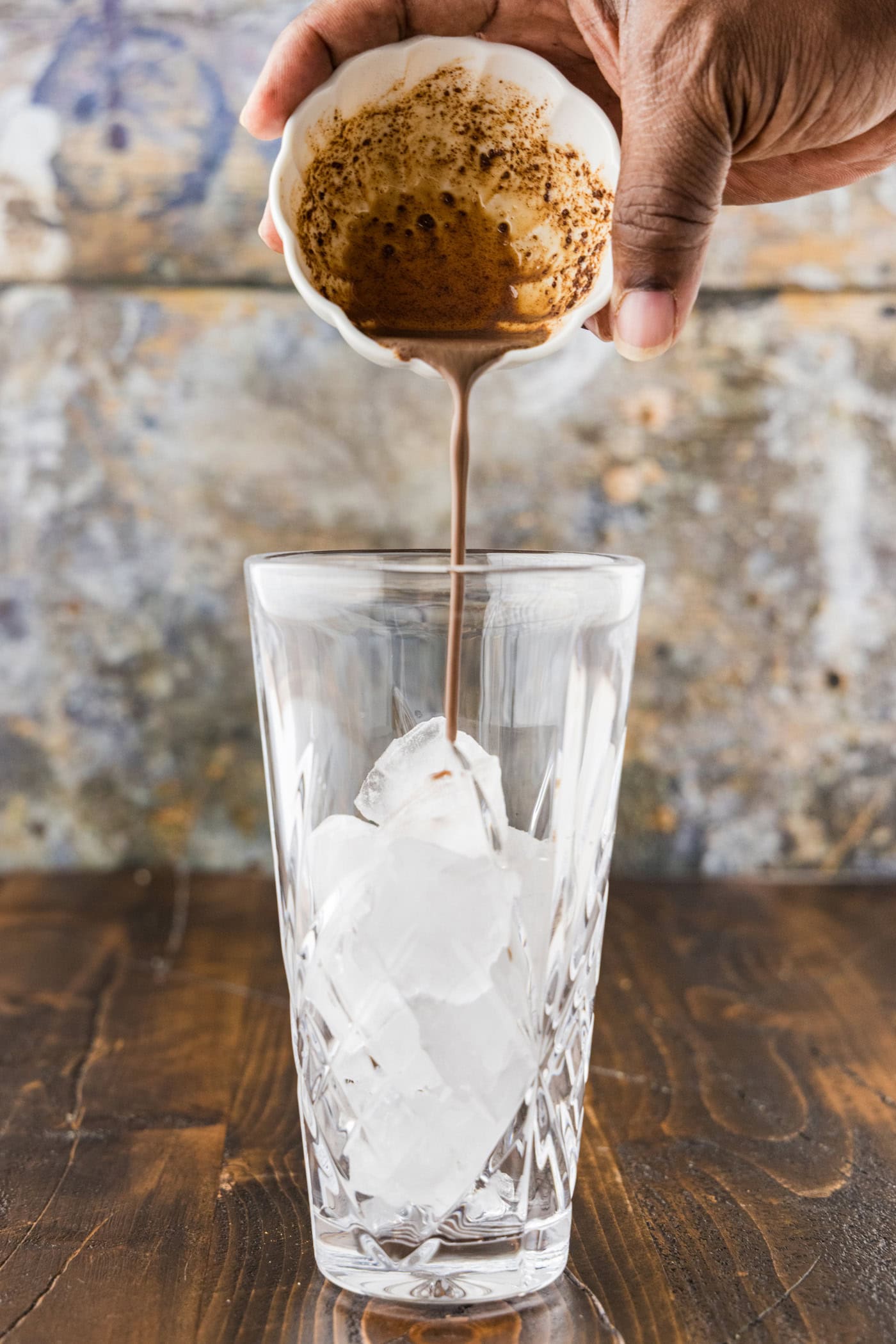 The pumpkin spice paste poured from the bowl into a cocktail shaker filled with ice