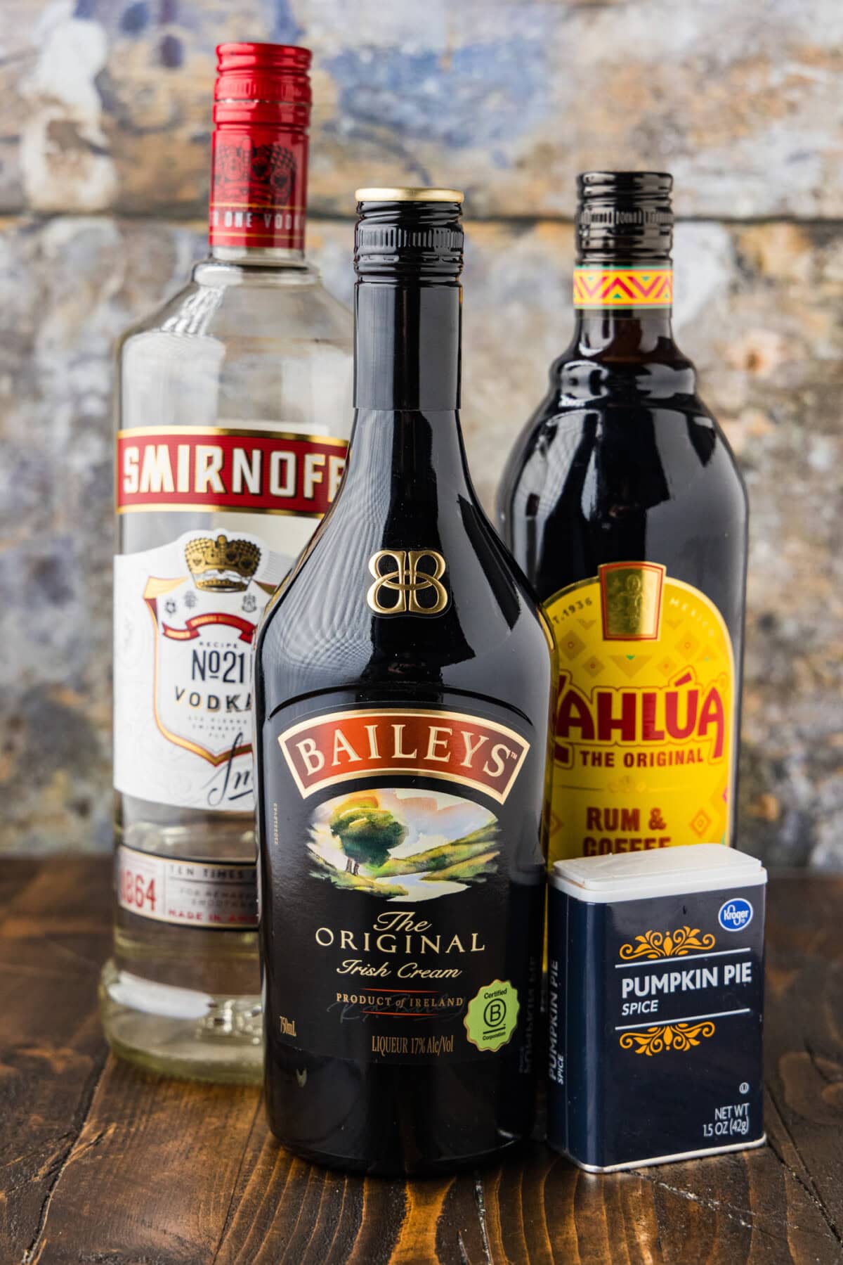 Ingredients for pumpkin spice mudslides including vodka, Irish cream, coffee liqueur and a tin of pumpkin pie spice