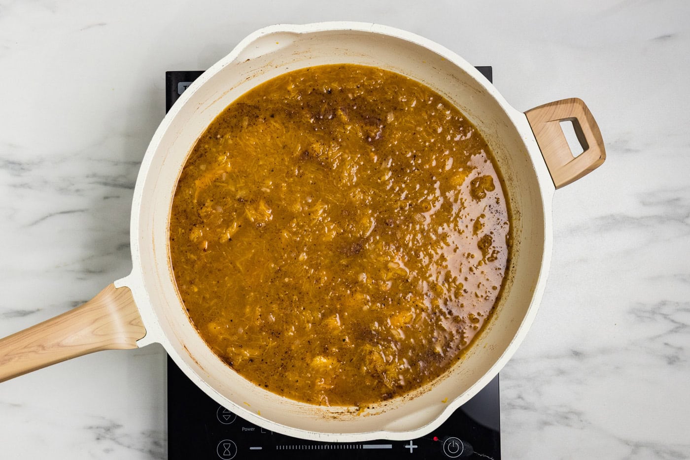 Roasted pumpkin, vegetable broth and warm spices stirred together in a skillet.